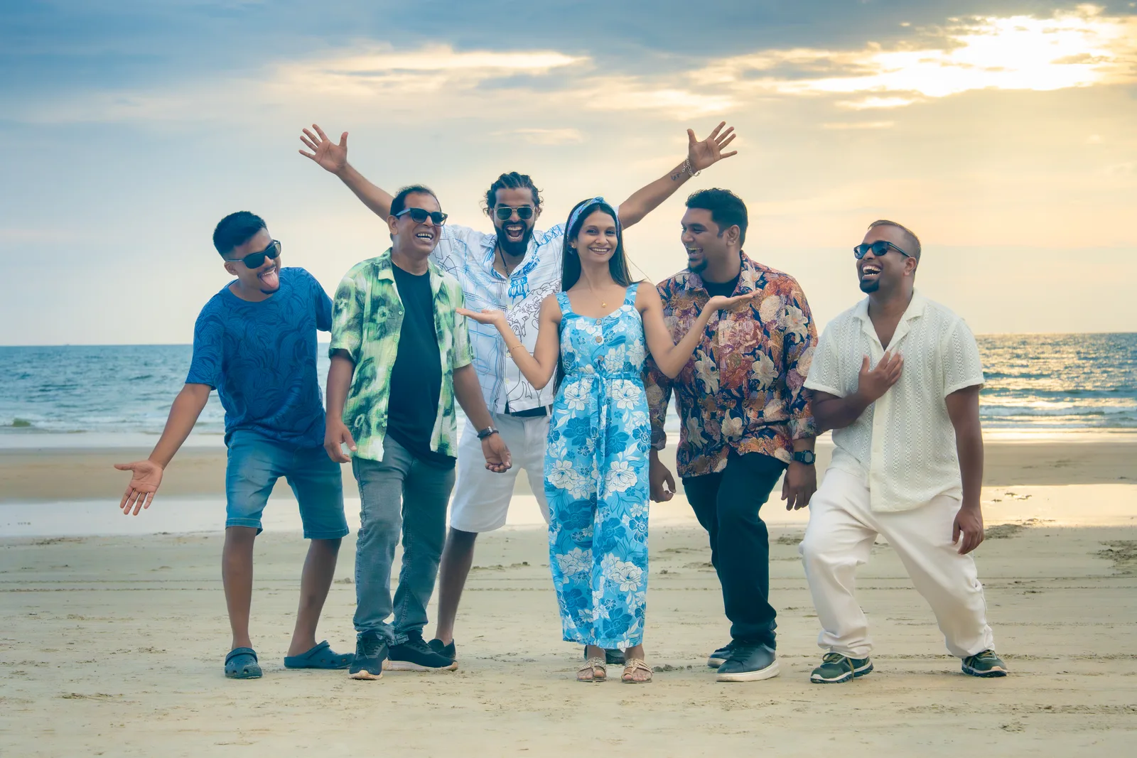 The six members of Big City Band laughing together on a beach in Goa